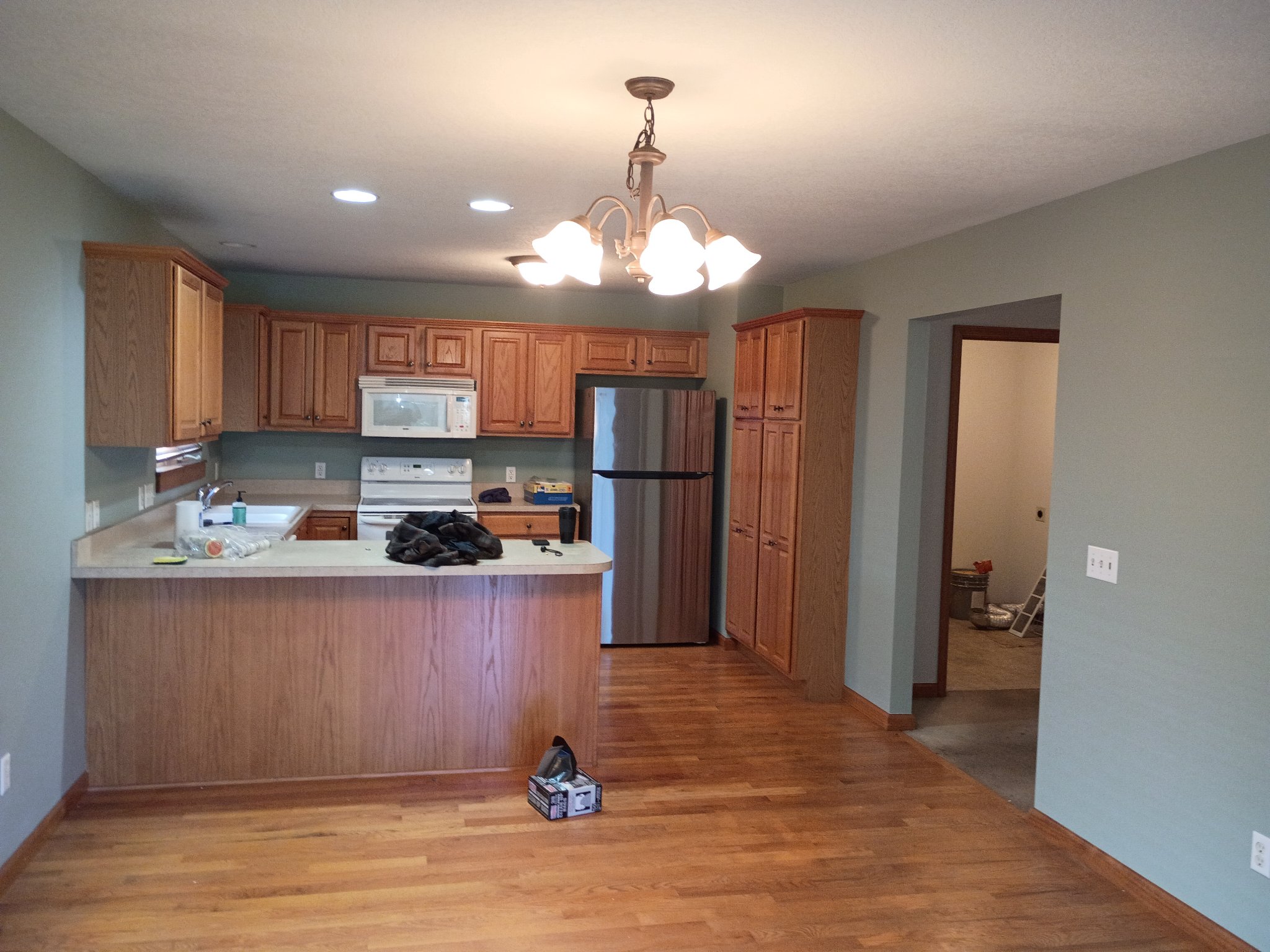 Kitchen repainted in Oyster Bay green with oak cabinets
