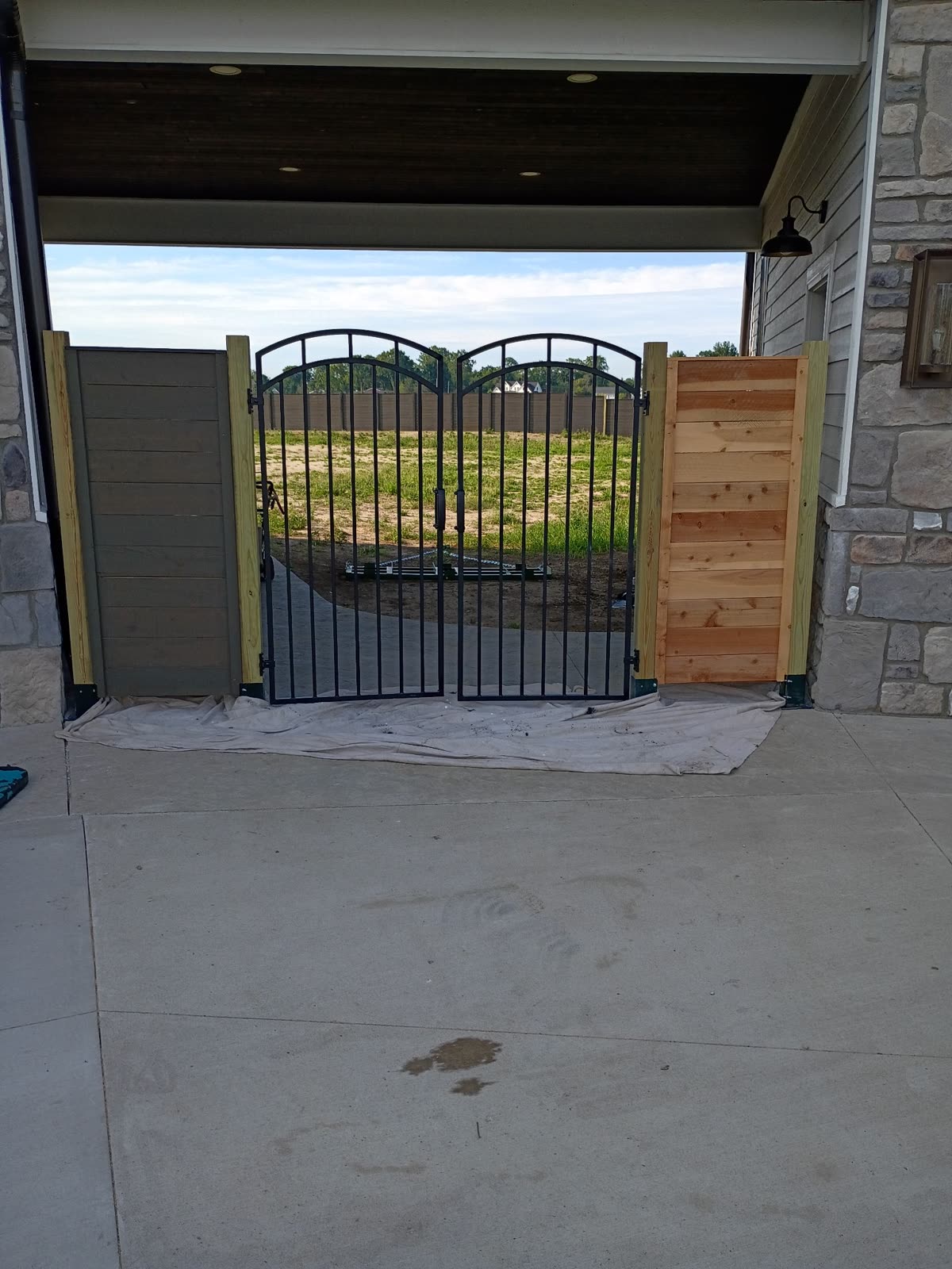 Iron gate with unstained cedar panels